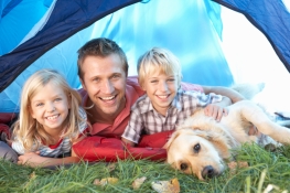 Young father poses with children in tent